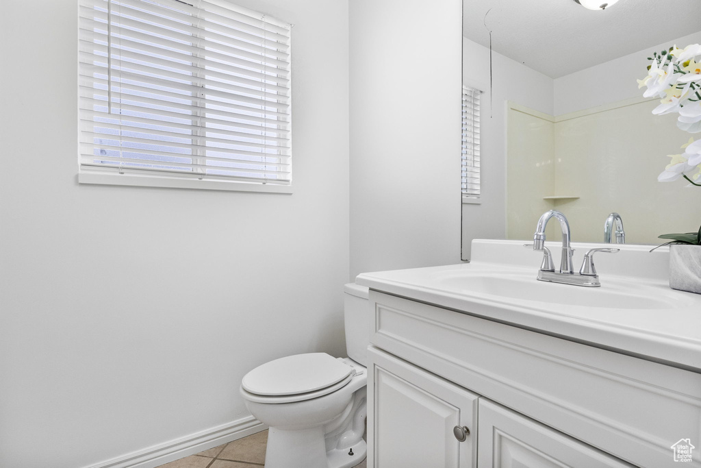 Bathroom featuring tile patterned floors, toilet, vanity, and baseboards
