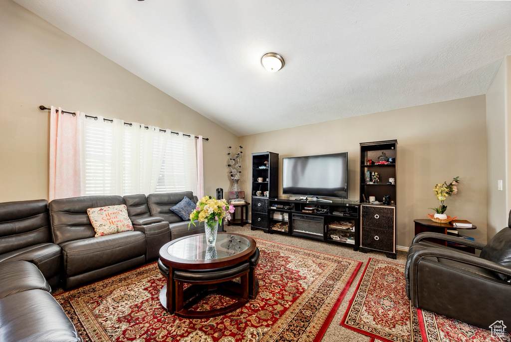 Carpeted living room with vaulted ceiling