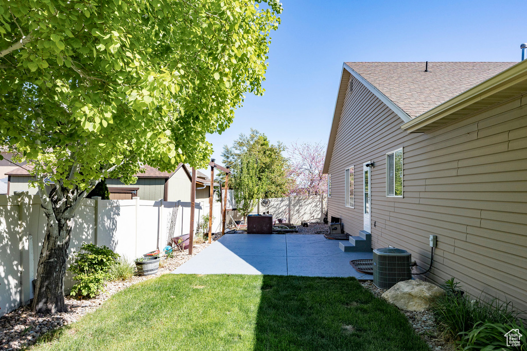 View of yard featuring cooling unit, a patio, and a fenced backyard