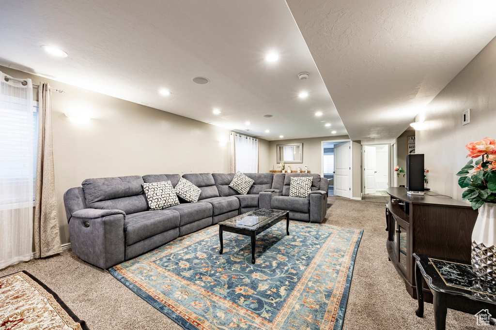 Living area with light carpet and recessed lighting