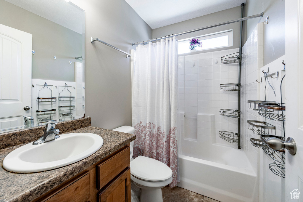 Full bathroom featuring vanity, toilet, and shower / bath combination with curtain