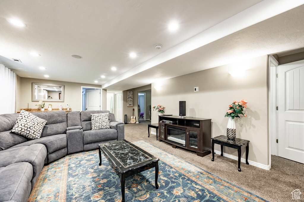 Carpeted living area featuring baseboards, visible vents, and recessed lighting