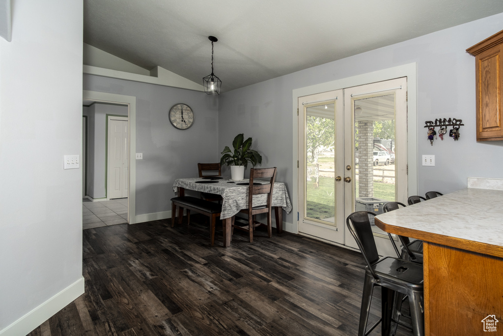 Dining space featuring french doors, dark wood-style flooring, baseboards, and lofted ceiling