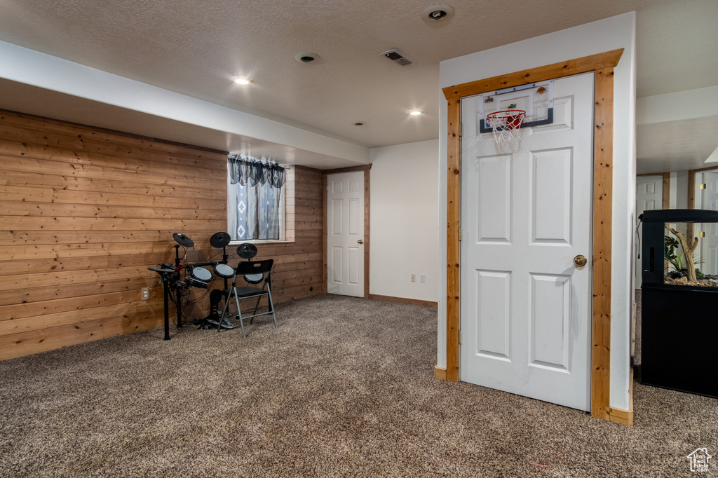 Finished basement with wood walls, carpet, and recessed lighting