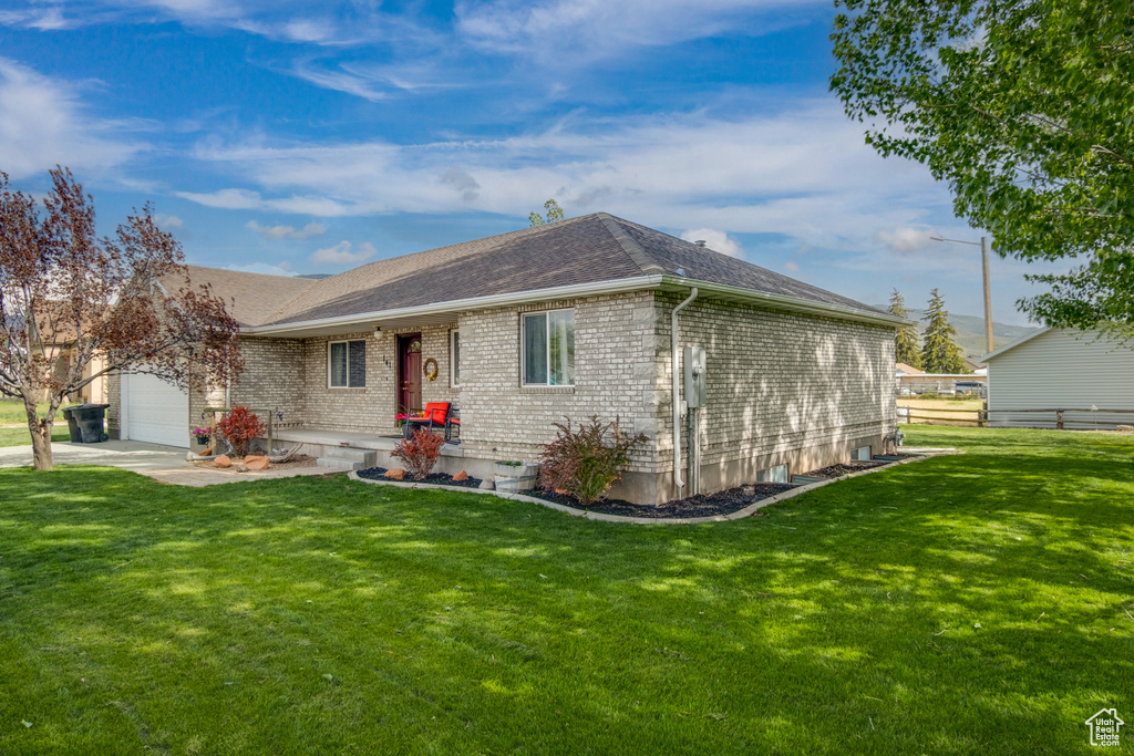 Ranch-style home featuring a garage, brick siding, and a shingled roof