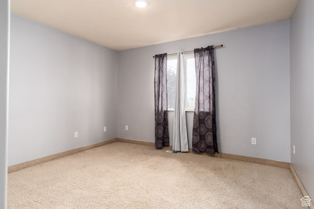 Carpeted empty room featuring baseboards