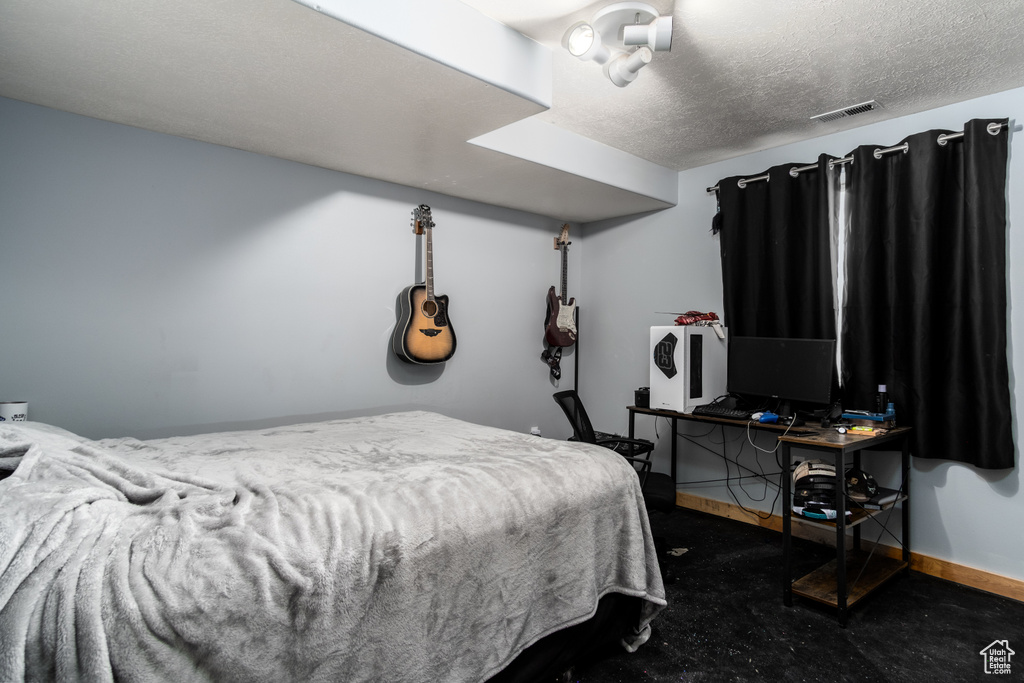 Bedroom featuring a textured ceiling and baseboards