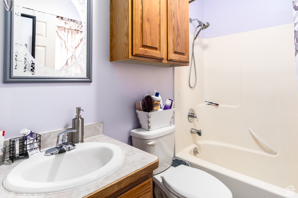 Bathroom with toilet, vanity, and tub / shower combination