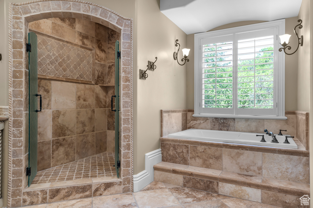 Full bathroom featuring a bath, a shower stall, and vaulted ceiling