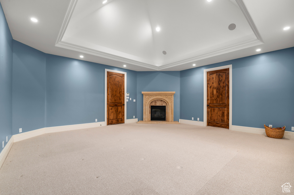 Unfurnished living room featuring a raised ceiling, carpet floors, recessed lighting, and baseboards