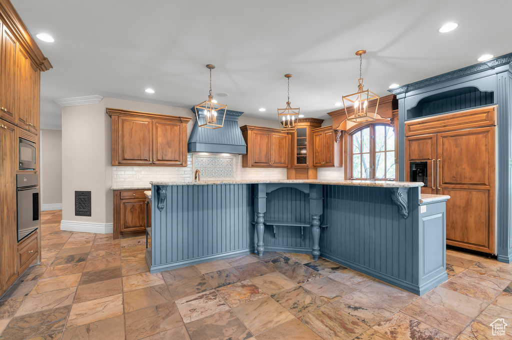 Kitchen with premium range hood, built in appliances, recessed lighting, a breakfast bar area, and baseboards