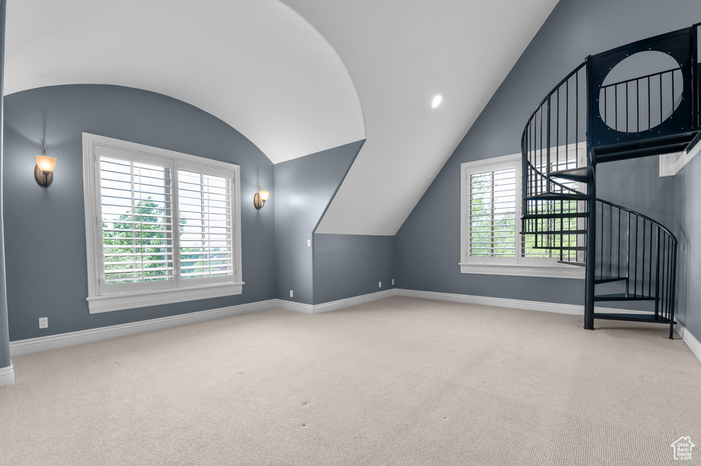 Additional living space featuring lofted ceiling, baseboards, carpet floors, and stairs