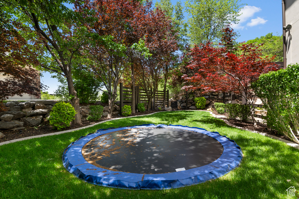 View of swimming pool featuring a trampoline and a yard