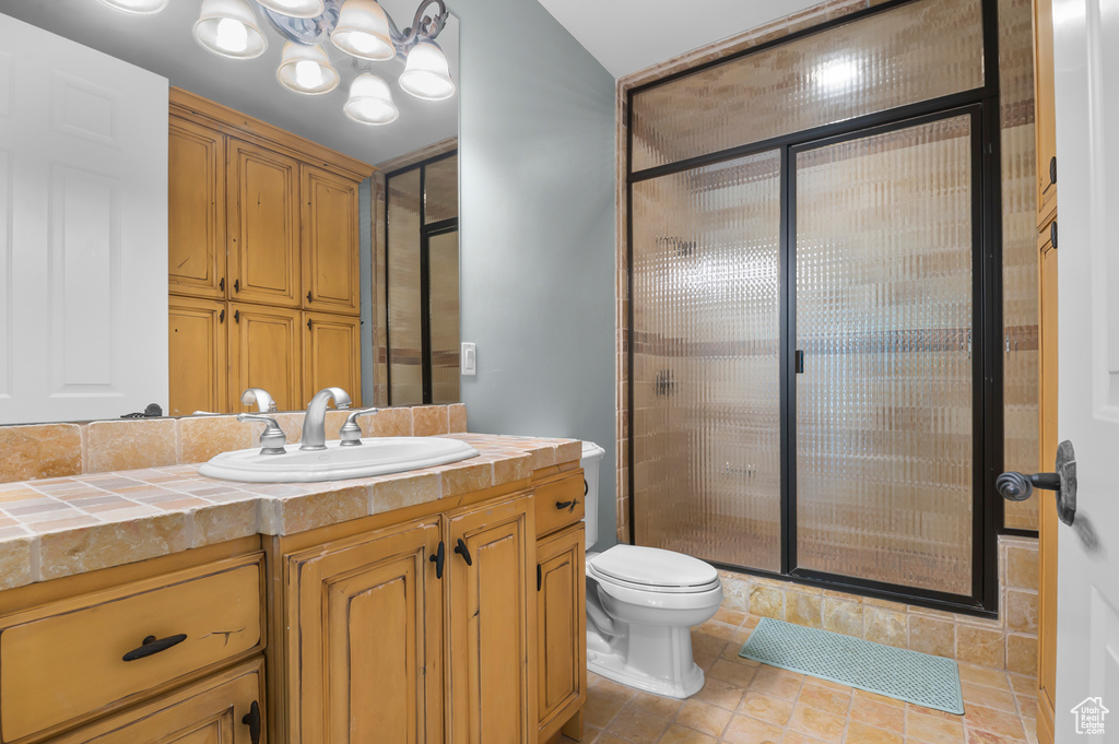 Bathroom featuring a shower stall, vanity, and toilet