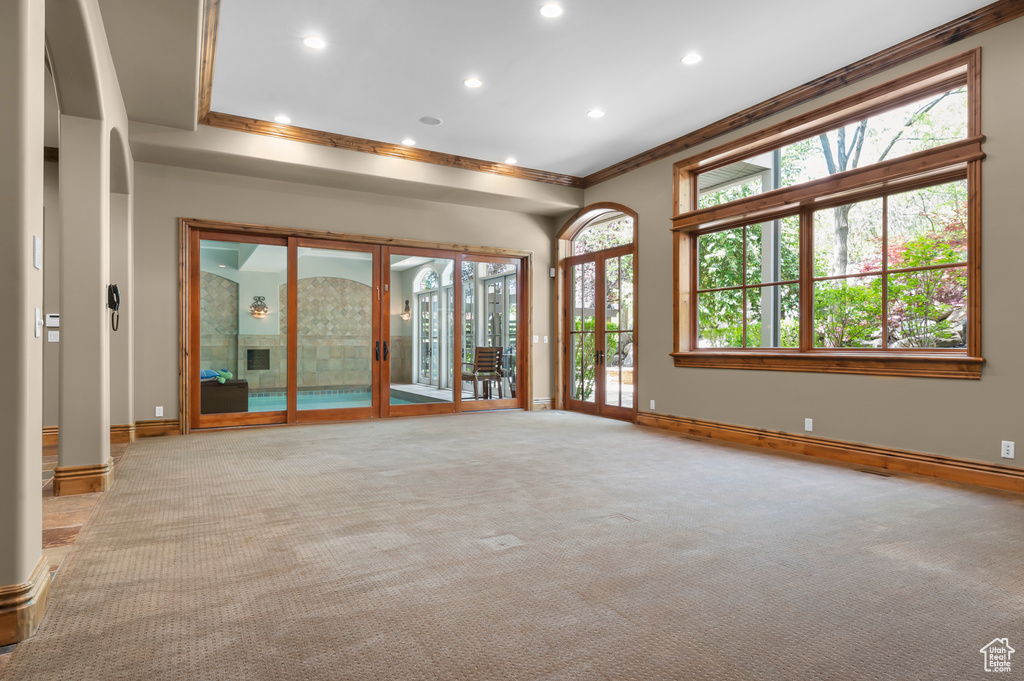Spare room featuring ornamental molding, baseboards, light colored carpet, and recessed lighting