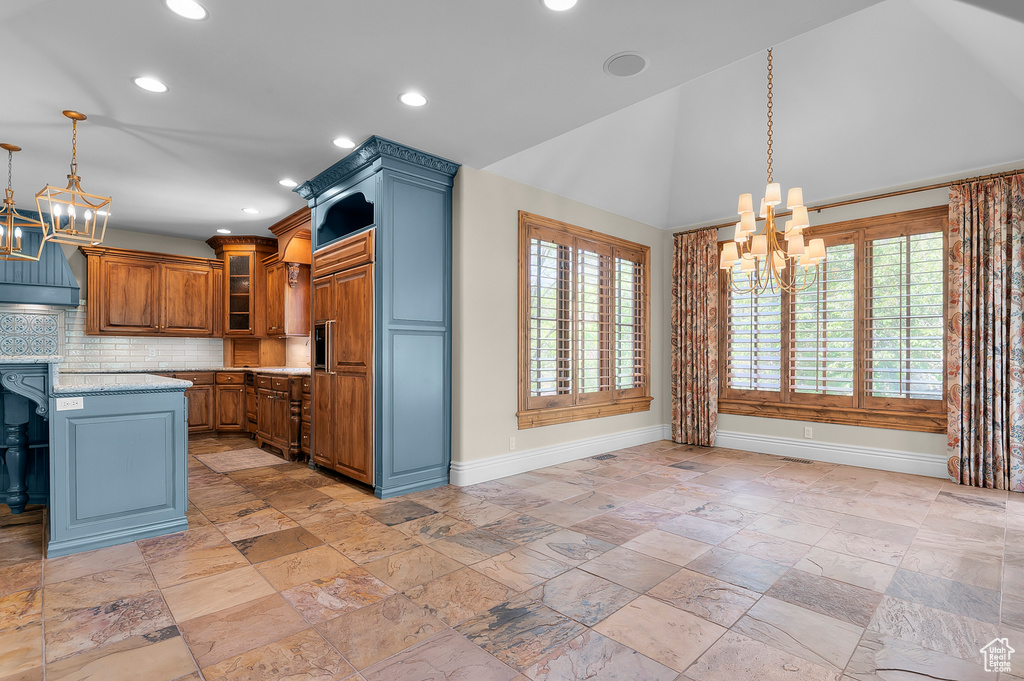 Kitchen with a chandelier, baseboards, backsplash, hanging light fixtures, and recessed lighting