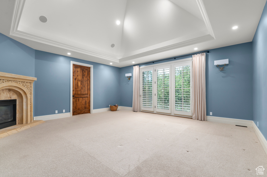 Unfurnished living room featuring a raised ceiling, recessed lighting, carpet, and a fireplace