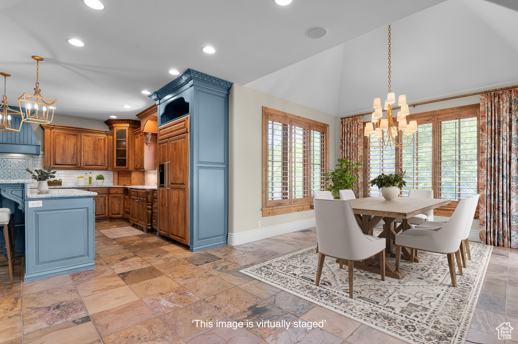 Dining area with a chandelier, baseboards, recessed lighting, high vaulted ceiling, and stone tile flooring