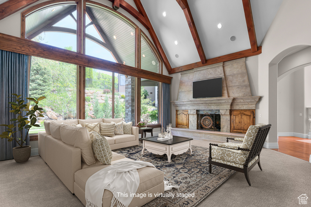Carpeted living area featuring healthy amount of natural light, beam ceiling, high vaulted ceiling, a premium fireplace, and recessed lighting