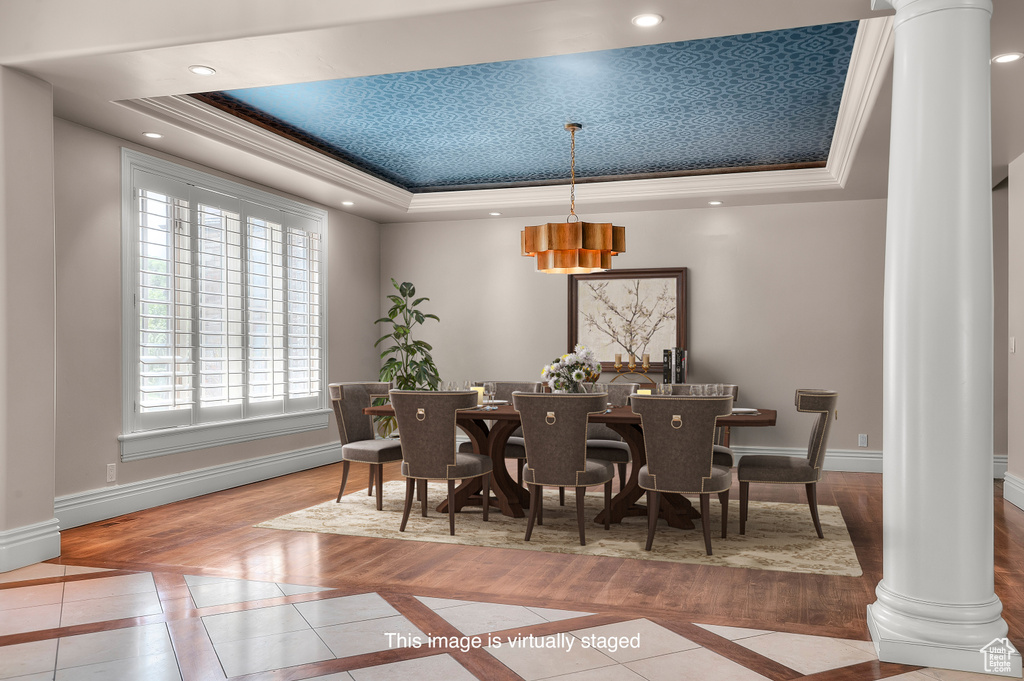 Dining room featuring decorative columns, a tray ceiling, inlaid floor details, crown molding, and recessed lighting
