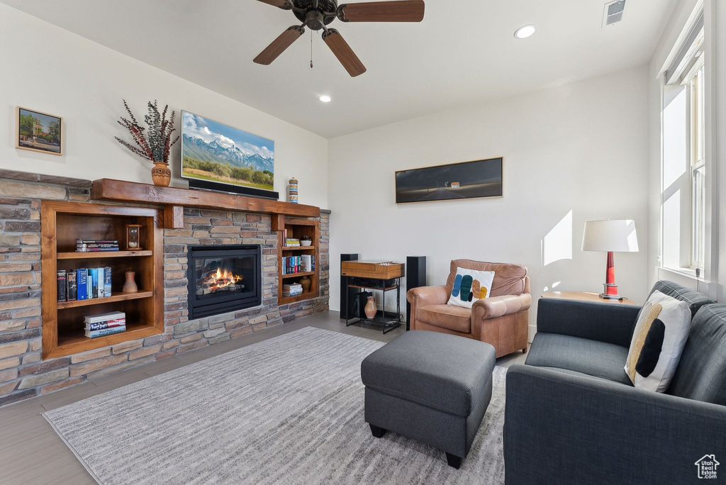 Living area with a fireplace, ceiling fan, and recessed lighting