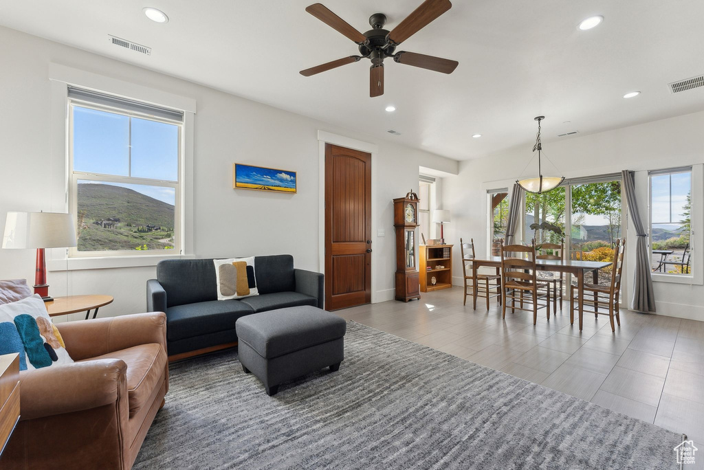 Living area with recessed lighting, plenty of natural light, a ceiling fan, and baseboards