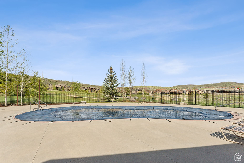 View of pool with fence, a patio, and a mountain view