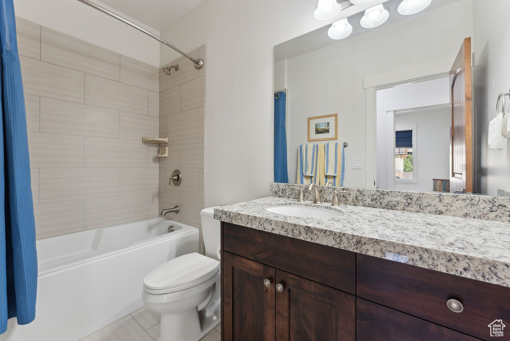 Full bath featuring toilet, vanity, shower / bathtub combination with curtain, and tile patterned flooring
