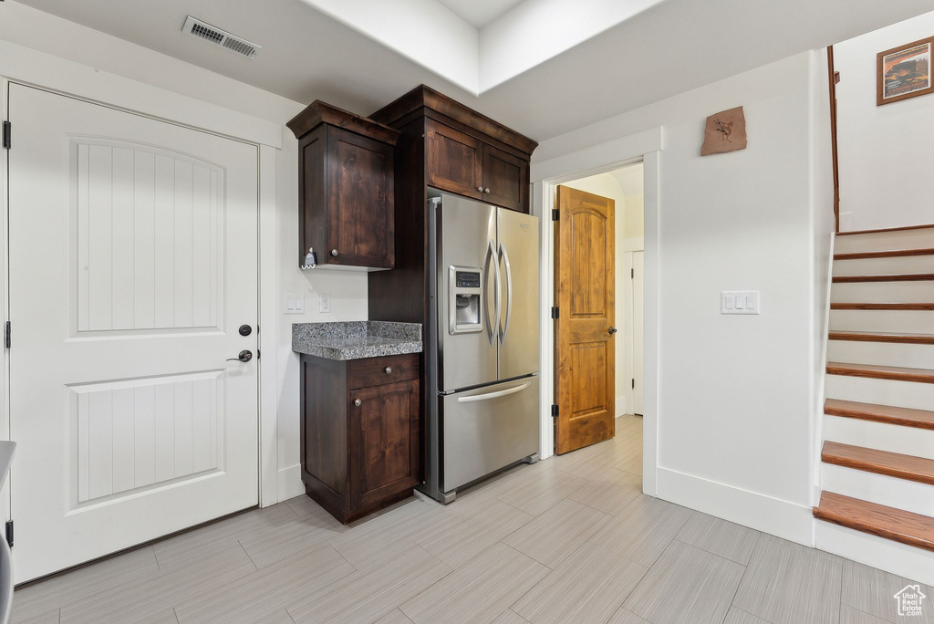 Kitchen with stainless steel refrigerator with ice dispenser and dark brown cabinets
