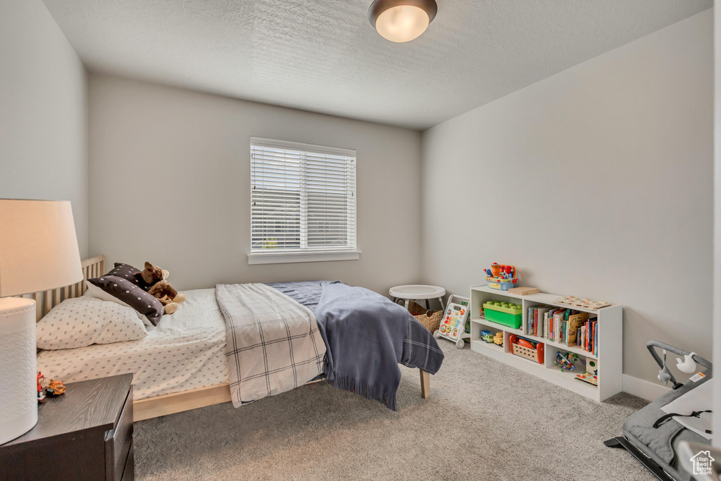 Carpeted bedroom with a textured ceiling