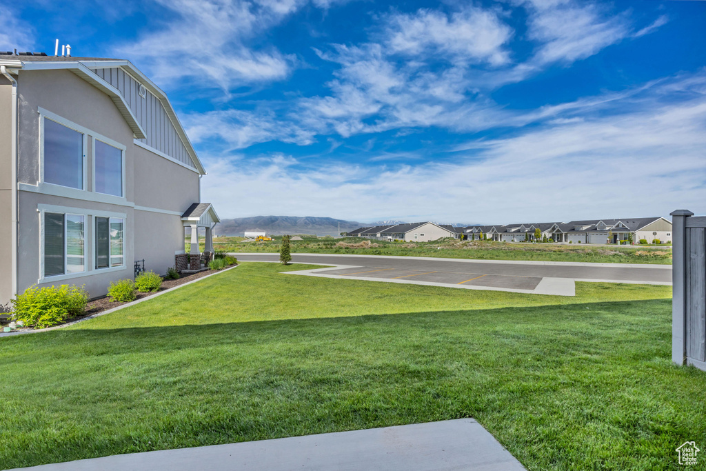 View of green lawn featuring a residential view and a mountain view