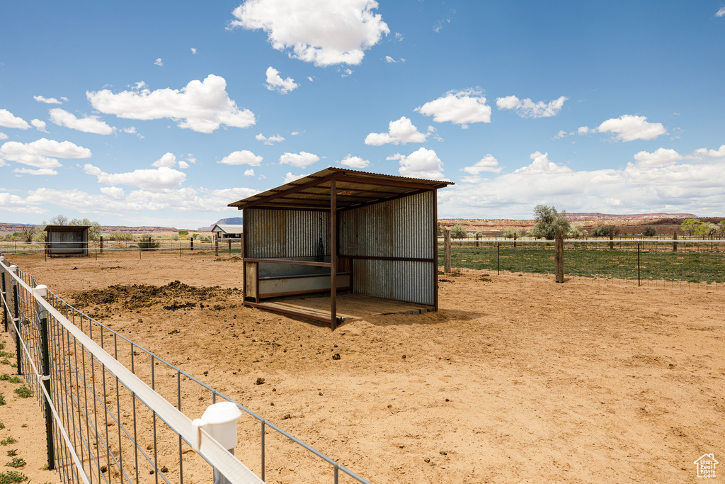 View of outbuilding featuring a view of rural / pastoral area, an outdoor structure, and fence