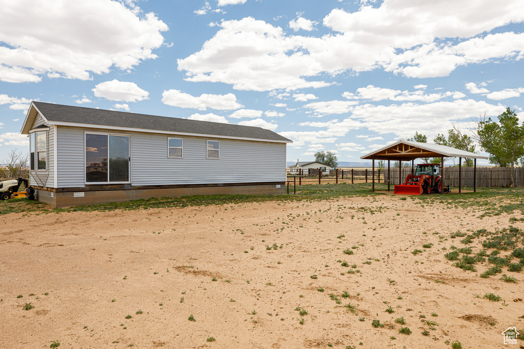 Back of property featuring a carport and fence