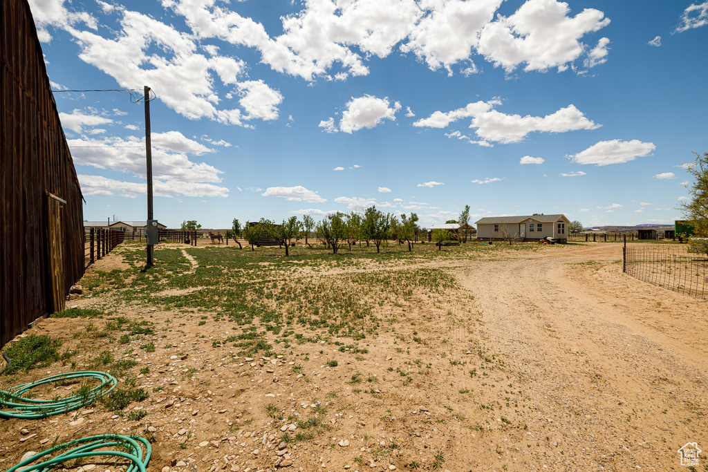 View of yard with a view of rural / pastoral area and fence