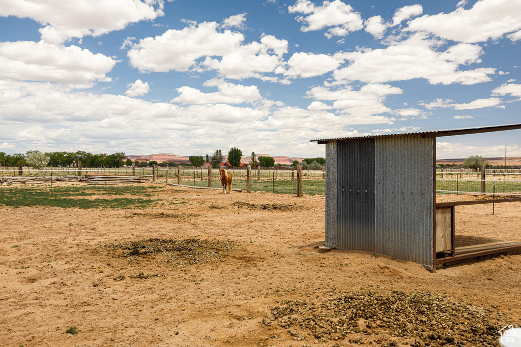 View of outbuilding featuring a view of rural / pastoral area, fence, and an outdoor structure