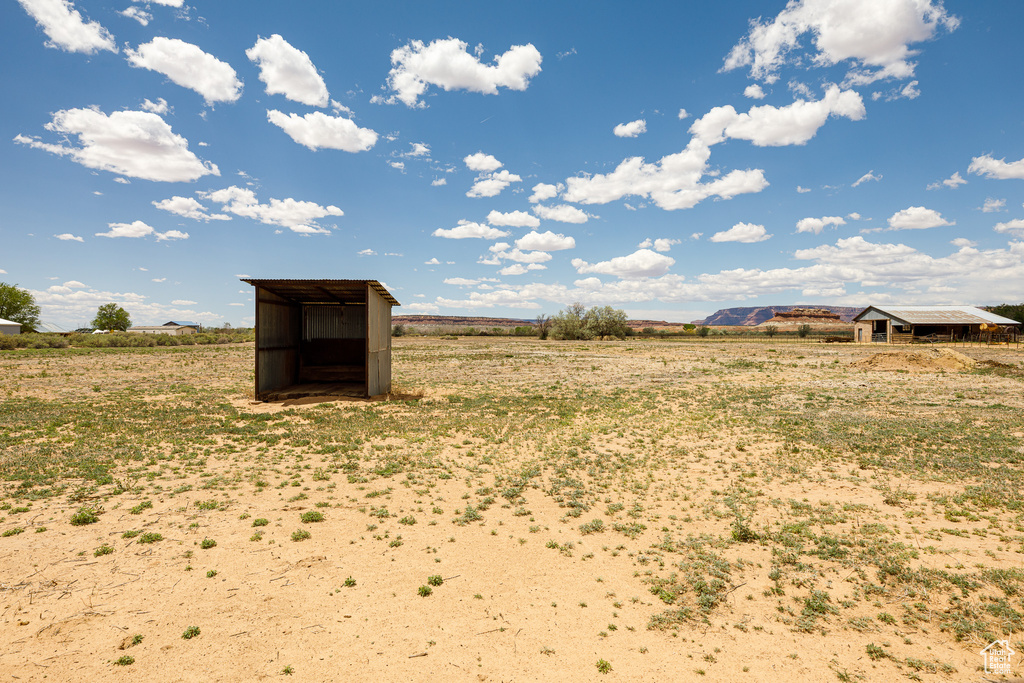 View of yard featuring a view of rural / pastoral area, an outbuilding, and a storage shed