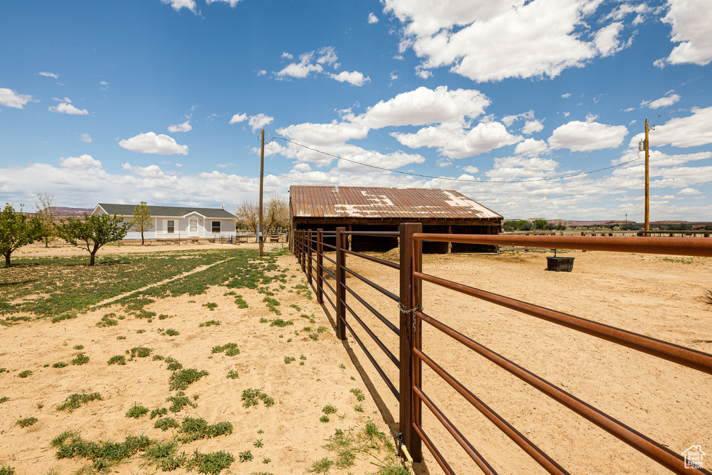 View of yard featuring an exterior structure, an outdoor structure, and a rural view