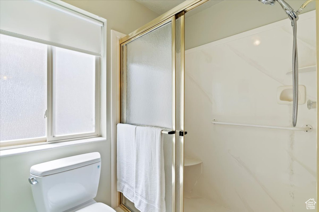 Full bath featuring a shower stall and toilet