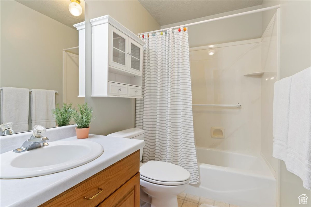 Bathroom with toilet, vanity, shower / bath combination with curtain, and tile patterned floors