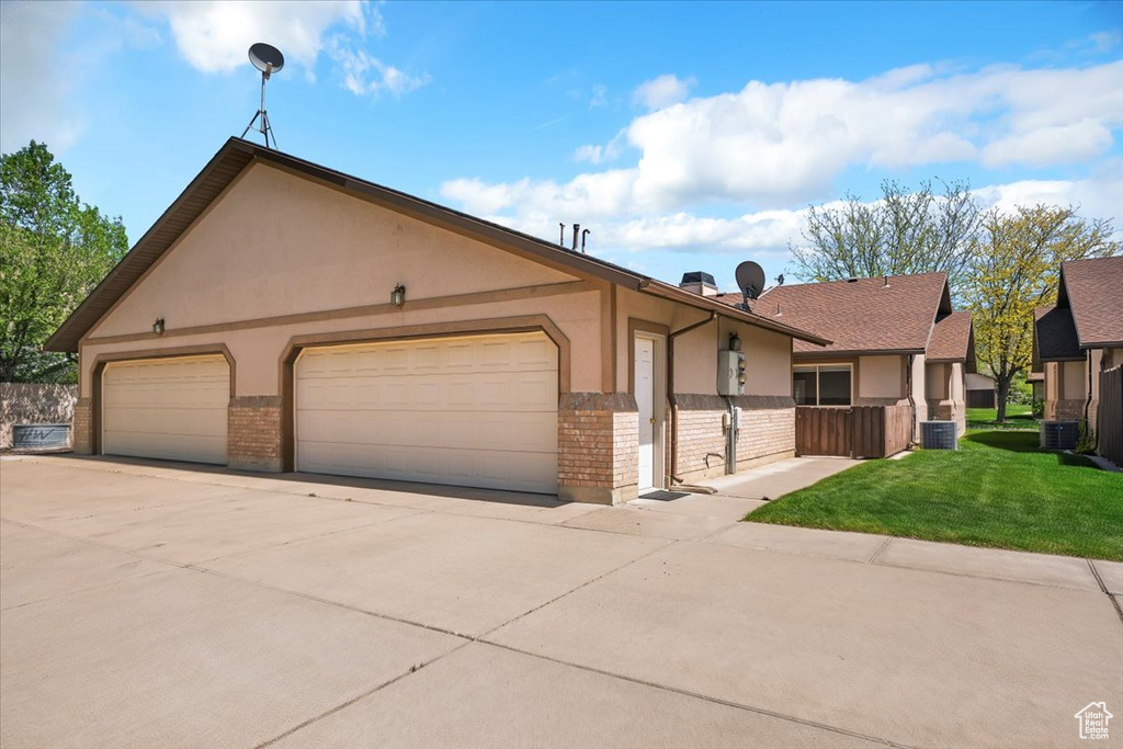 View of front of home with stucco siding, brick siding, driveway, and a garage