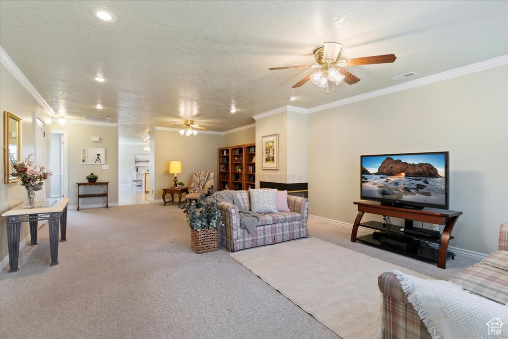 Living room with a ceiling fan, light colored carpet, ornamental molding, baseboards, and recessed lighting