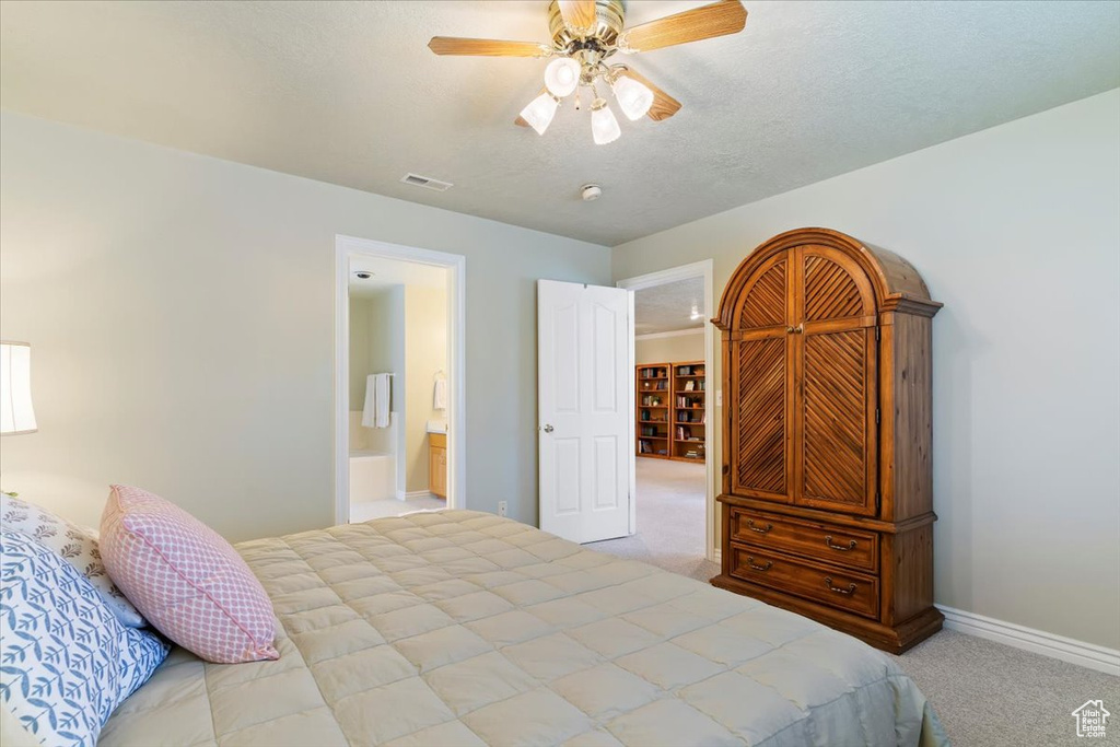 Bedroom with carpet, baseboards, a ceiling fan, a textured ceiling, and ensuite bathroom