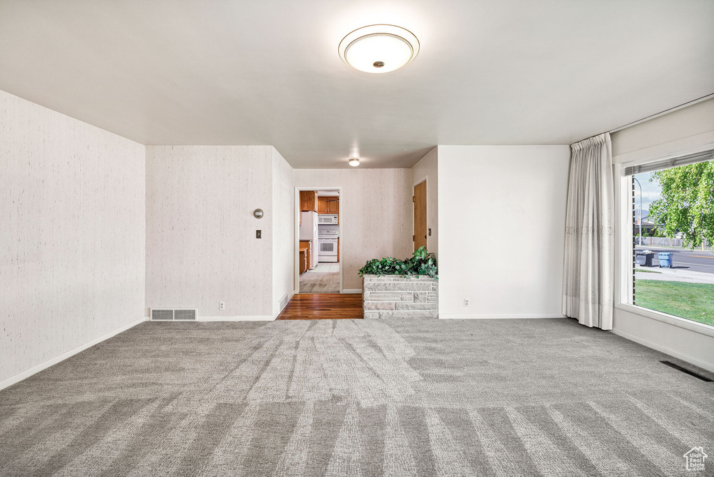 Spare room with carpet and baseboards