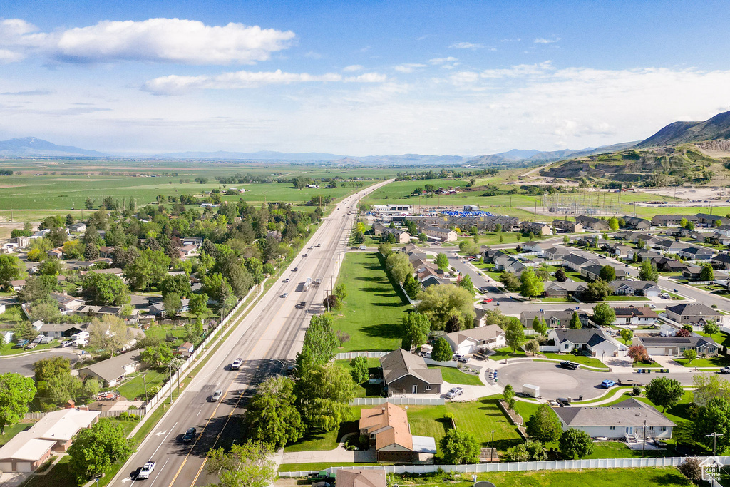 Aerial view of property\'s location featuring a mountainous background, a major roadway, and nearby suburban area