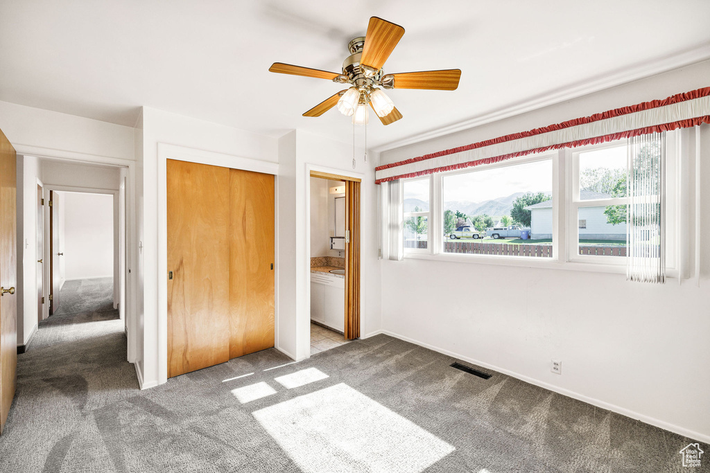 Unfurnished bedroom with carpet flooring, a closet, baseboards, and ceiling fan