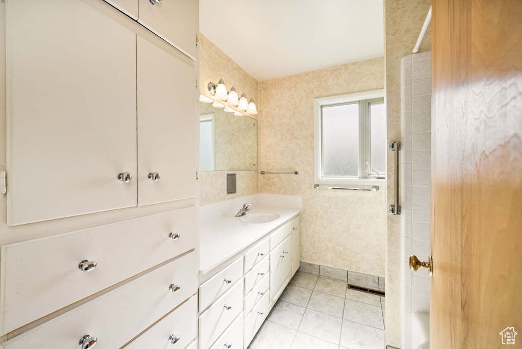 Bathroom with vanity, a shower, and tile patterned floors