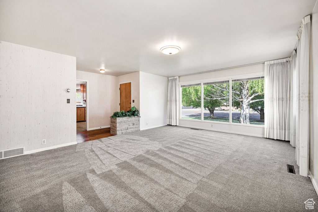 Carpeted empty room with baseboards