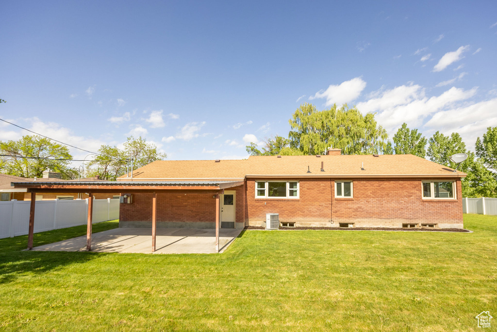 Rear view of house featuring a patio area, brick siding, and cooling unit