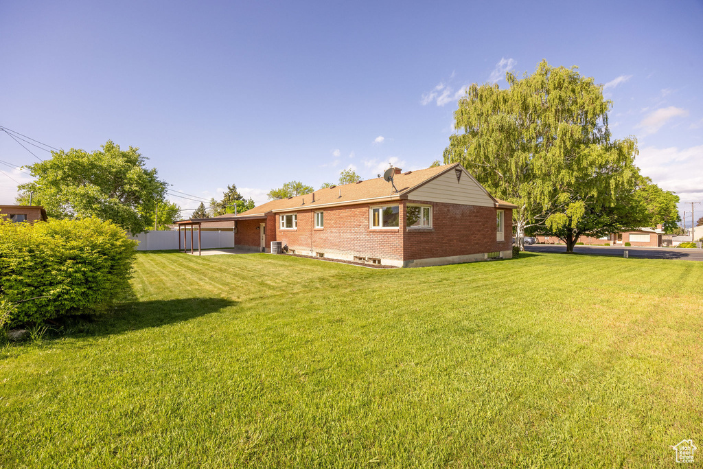 Back of property with brick siding and a lawn
