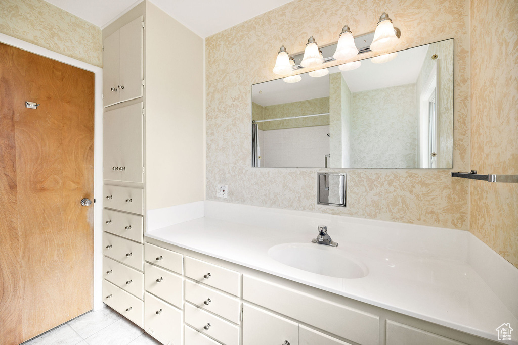 Full bath featuring vanity, tile patterned floors, and a shower